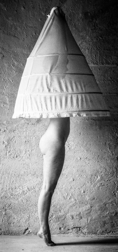 Eine figurative Darstellung mit einer Person, die einen konischen Stoff über dem Kopf trägt.